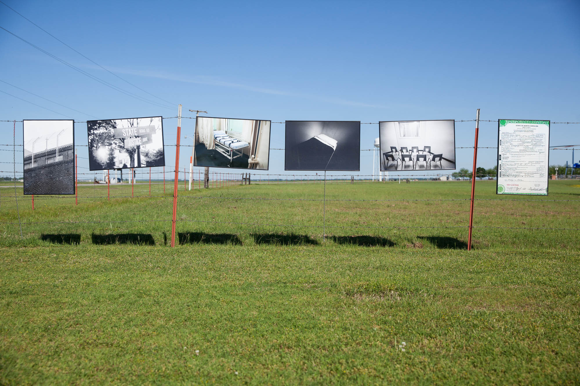 Scott Langley’s death penalty photography exhibit, hanging on barbed wire fencing outside the Arkansas execution facilities.