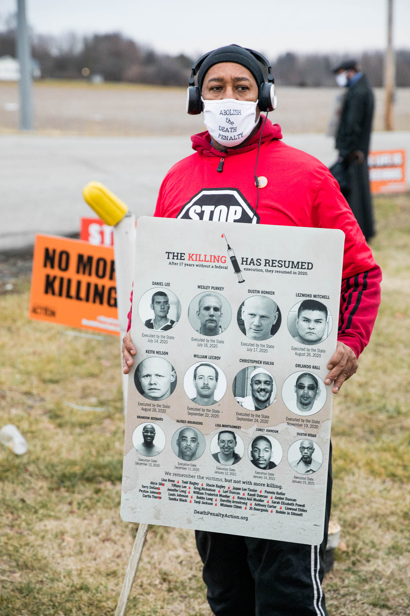 Charles Keith, whose brother used to be on death row, vigils outside the prison in Terre Haute, holding a poster of the 13 prisoners killed by the Trump Administration